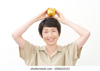 Portrait Of Asian Middle Aged Woman With The Piggy Bank In White Background