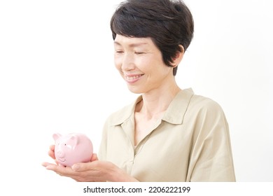 Portrait Of Asian Middle Aged Woman With The Piggy Bank In White Background