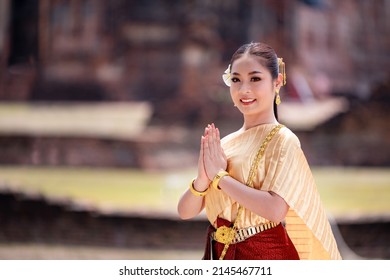 Portrait Asian model posing to pay respect with smiling wearing Thai dress traditional costume greeting  happy new year thailand songkran festival.