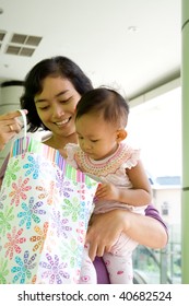 Portrait Of Asian Mother And Baby Girl Having Fun Shopping At The Mall