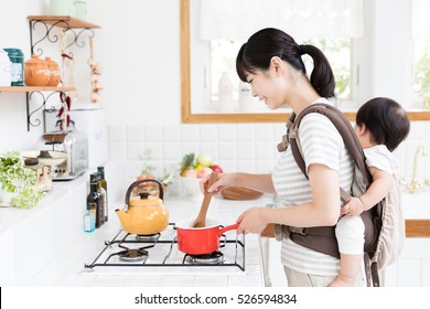 portrait of asian mother and baby in the kitchen