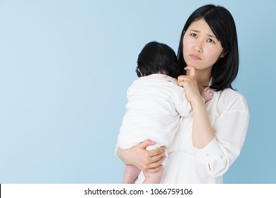 Portrait Of Asian Mother And Baby On Blue Background