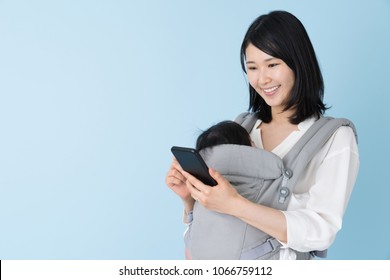 Portrait Of Asian Mother And Baby On Blue Background