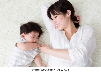 portrait of asian mother and baby sleeping in the room