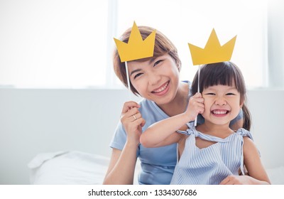 Portrait Of Asian Mother And Child Daughter Playing Having Fun Together. Beautiful Funny Girl Mommy Have Crowns On Sticks. Fun Love Family Day Lifestyle Single Mom Love Mother’s Day Holiday Concept