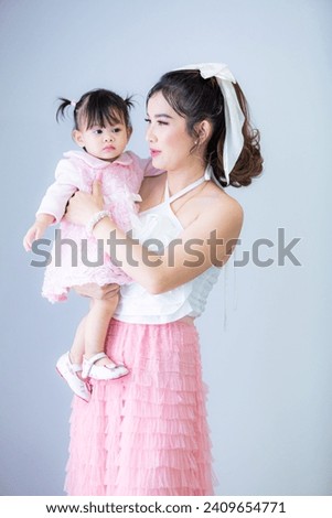 Portrait of Asian mother and child on background,Asian mom hold baby smile and kissing on baby cheek happiness moment together isolated on white background. 