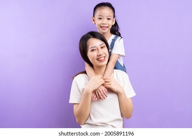 Portrait Of Asian Mother And Daughter On Purple Background