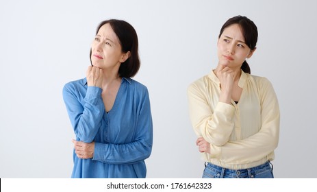 Portrait Of Asian Mother And Daughter Thinking On White Background