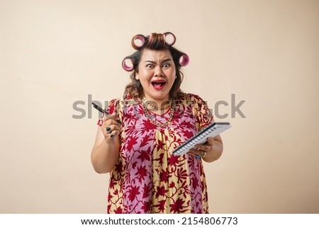 Portrait of an Asian mother with sad face holding her book. Isolated on creame background.
