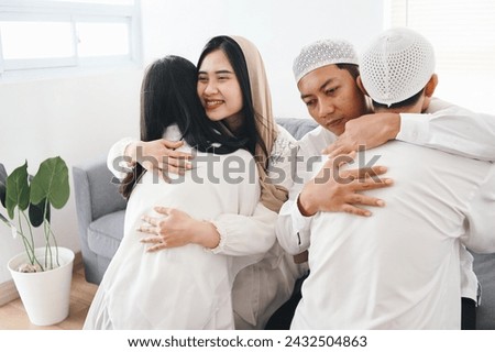 Portrait of Asian muslim family, parents and children hugging and forgive each other at Eid mubarak moment. Islamic culture and tradition