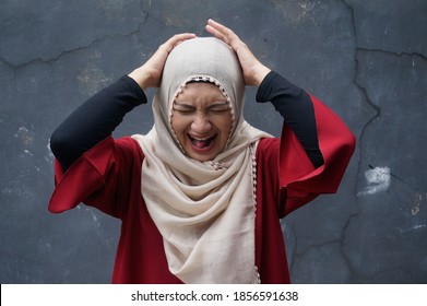 Portrait Of Asian Muslim Lady Wearing Hijab Hold Her Head In Pain For Stress, Angry Or Emotional Breakdown 