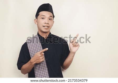 Portrait of asian muslim man standing and showing side on isolated background