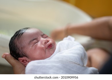 Portrait Of A Asian New Born Baby Close Eyes While Taking Bath.Selective Focus On The Baby.