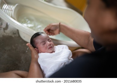 Portrait Of A Asian New Born Baby Close Eyes While Taking Bath.Selective Focus On The Baby.