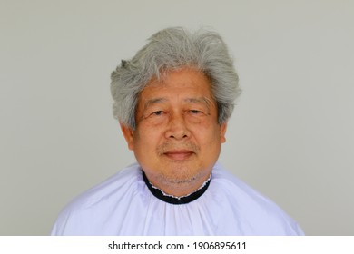 Portrait Of Asian Old Man With Gray Hair In Shawl Cover For Hair Cut At Home. Senior Guy Do Like A Barber Professional.