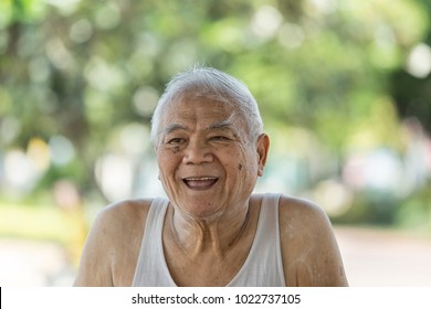 A Portrait Of Asian Old Retire Who Has Alzheimer's Disease. Laughing 80 Year Old Senior Man Candid Portrait Very Happy When Go To Park. Funny 80 Year's Man Looking At Camera. Concept Happy People.