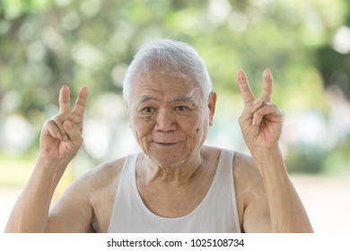 A Portrait Of Asian Old Retire Who Has Alzheimer's Disease.Laughing 80 Year Old Senior Man Candid Portrait Very Happy When Go To Park. Funny Senior Asian Man Looking At Camera. Concept Happy People.
