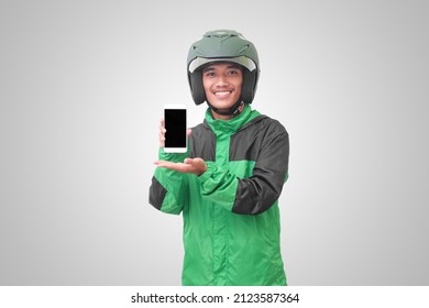 Portrait Of Asian Online Taxi Driver Wearing Green Jacket And Helmet Showing And Presenting Blank Screen Mobile Phone. Isolated Image On White Background