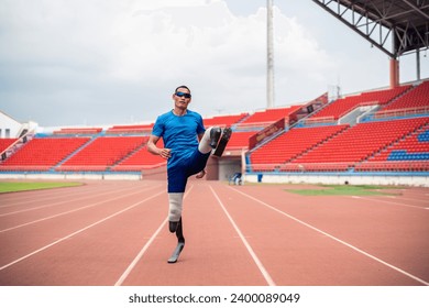 Portrait of Asian para-athletes disabled with prosthetic in stadium. Attractive amputee male runner looking at camera after practicing for Paralympics competition regardless of physical limitations. - Powered by Shutterstock