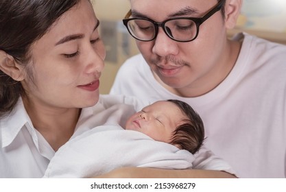 Portrait Of Asian Parents Newborn Baby Day, Closeup Portrait Of Asian Young Couple Father Mother Holding New Born Baby In Hospital Bed. Happy Asia Lovely Family, Nursery Breastfeeding Mother’s Day