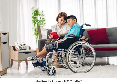 Portrait of asian physiotherapist carer helping and playing with special disabled child health problem by doing exercises sitting in wheelchair in rehabilitation clinic.disability care concept - Powered by Shutterstock