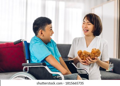 Portrait Of Asian Physiotherapist Carer Helping And Playing With Special Disabled Child Health Problem By Doing Exercises Sitting In Wheelchair In Rehabilitation Clinic.disability Care Concept