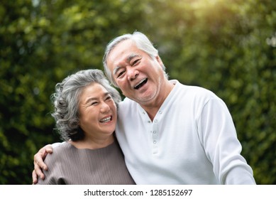 Portrait Of Asian Senior Couple In Casual Laughing Over Green Nature At Park Outdoor. Happy Smiling Elderly Man, Woman Enjoying With Positive Emotions At Garden. People Health Care, Family Lifestyle