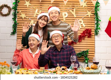 Portrait Of An Asian Senior Couple With Christmas Dinner Party  With Santa Claus Hats And Gift.Happy Asian Family Is Smiling At The Camera.