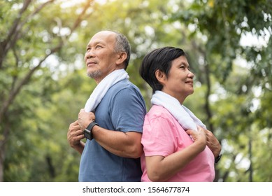 Portrait Of Asian Senior Couple Standing Over Green Nature Background. Elderly Man And Woman Exercising At Park Outdoor Together.