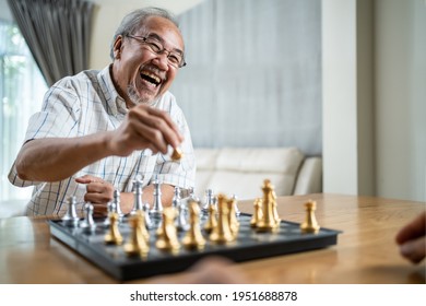 Portrait Of Asian Senior Elderly Male Spend Leisure Time, Stay Home After Retirement. Happy Smiling Old Man Enjoy Activity In House Play Chess Game With Friend. Hospital Healthcare And Medical Concept