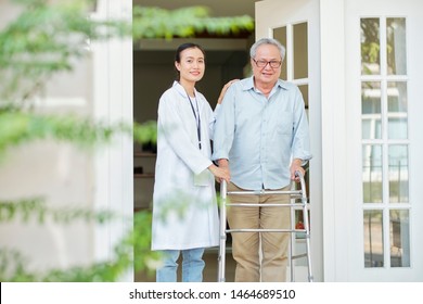 Portrait Of Asian Senior Man With Walker Walking Outdoors Together With Asian Young Nurse He Lives At Nursing Home