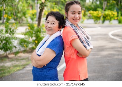 Portrait Asian Senior Mother And Teenager Daughter With Exercise Walking Or Jogging At Park	