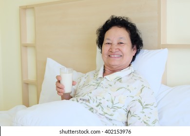 Portrait Of Asian Senior Woman Drinking Milk On Bed