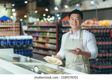 Portrait of Asian store manager, man with tablet checking expiration date of products, seller smiling and looking at camera near refrigerator in supermarket - Powered by Shutterstock