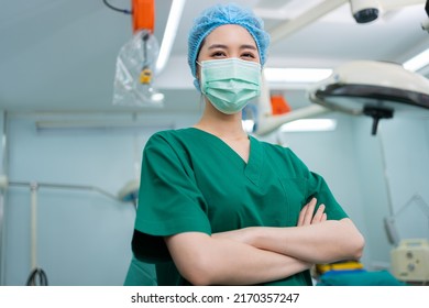 Portrait Of Asian Surgeon And Nurse With Medical Mask Standing With Arms Crossed In Operation Theater At A Hospital. Team Of Professional Surgeons. Healthcare, Emergency Medical Service Concept