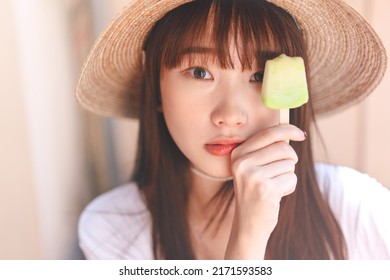 Portrait Asian Teenager Woman On Summer Vacation. Relax Eating Ice Cream At Home Outdoor Garden. Girl Wear White Shirt And Country Hat Style.