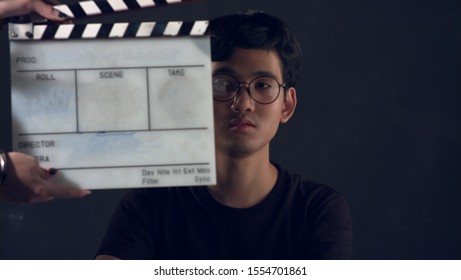 Portrait Of Asian Thai Teen Face With White Film Slate For Filmmaking. Space For Text