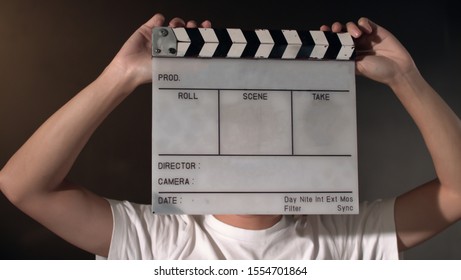 Portrait Of Asian Thai Teen Face With White Film Slate For Filmmaking. Space For Text