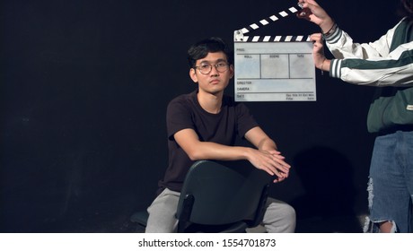 Portrait Of Asian Thai Teen Face With White Film Slate For Filmmaking. Space For Text