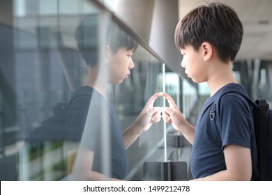 Portrait Of An Asian Tween Student Boy (12 -15 Years Old) Standing Alone Lost In Thought On The Walkway At School. Bullying, Teen Problem, Physical Or Emotional Harm, Loneliness, Withdrawn, Introvert.