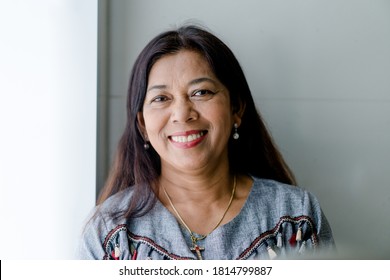 Portrait Of Asian Woman 60s Smile Looking Camera At Home During Covid19 Coronavirus.Vaccine With Senior 60 Christian Woman. Senior Adult Women Smiling Happy With Retirement Life.Dental Care.Unaltered