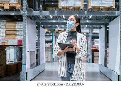 Portrait Of Asian Woman Business Owner Wear Mask Use Tablet Checking Amount Of Stock Product Inventory On Shelf At Distribution Warehouse Factory.logistic Business Shipping And Delivery Service