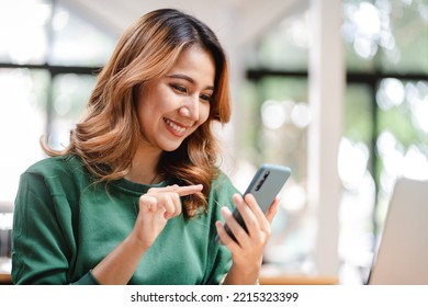 Portrait of an Asian woman holding a smartphone, typing messages, chatting with friends. on social networks mobile application concept Shopping online, browsing the web, ordering food - Shutterstock ID 2215323399