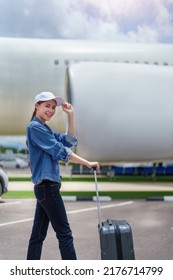 Portrait Of An Asian Woman Holding A Suitcase For A Trip After Getting Off An Economy Class Plane, Concept Vacation, Tourism