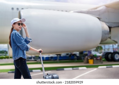 Portrait Of An Asian Woman Holding A Suitcase For A Trip After Getting Off An Economy Class Plane, Concept Vacation, Tourism