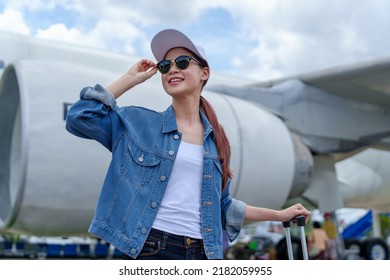 Portrait Of An Asian Woman Holding A Suitcase For A Trip After Getting Off An Economy Class Plane, Concept Vacation, Tourism