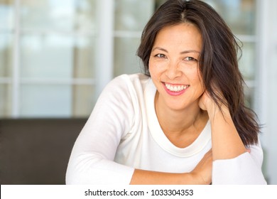 Portrait Of An Asian Woman Laughing And Smiling.