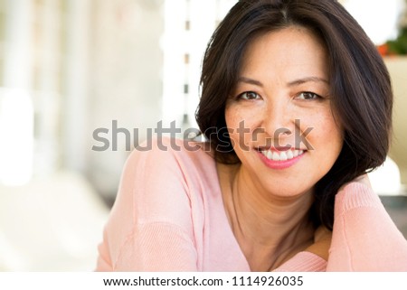 Portrait of an Asian woman laughing and smiling.