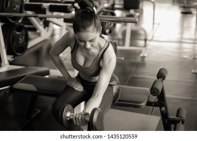 Portrait asian woman lifting weight with dumbbell and wearing sportswear in fitness or gym center, Strength sporty female and weight loss concept, monochrome - Shutterstock ID 1435120559