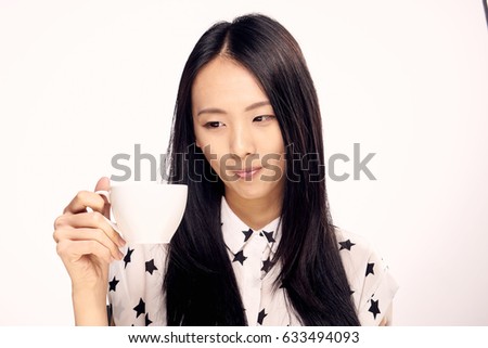 Portrait of Asian woman with a mug of coffee                               